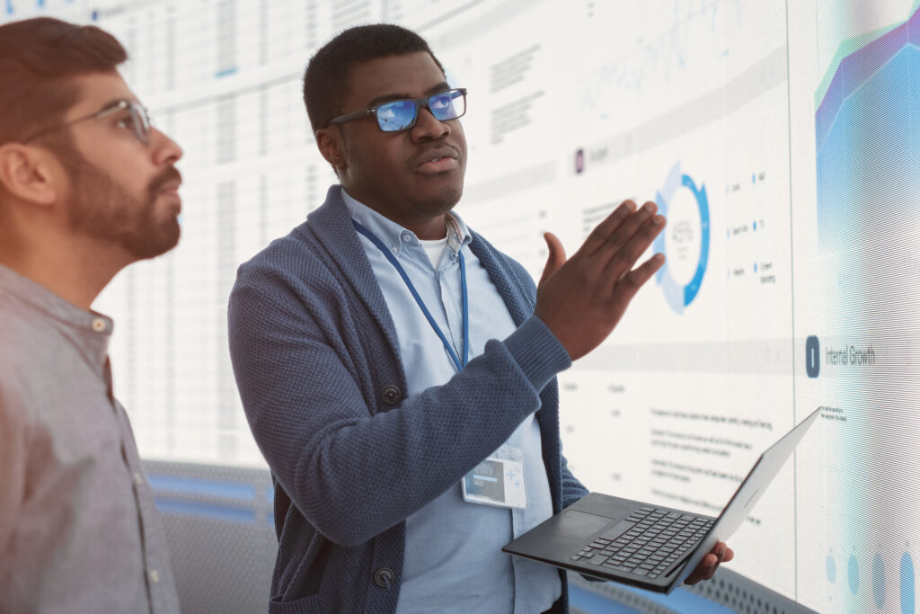 MASSIVE SOFTWARE LLC for Data Analytics Teams - Two men working in front of a screen that showcases different charts and graphs