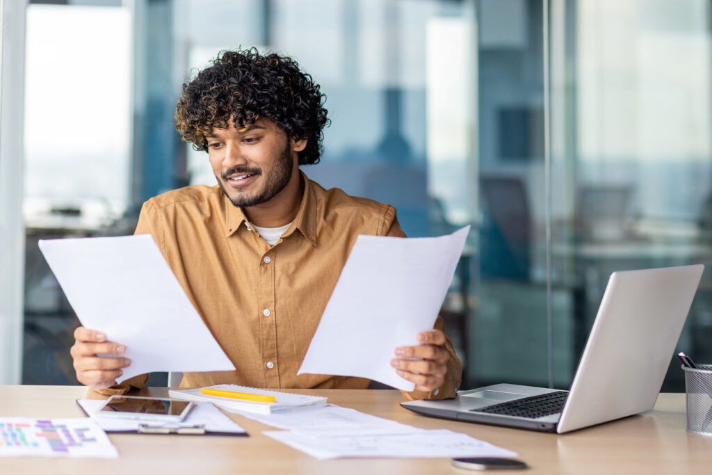 MASSIVE SOFTWARE LLC for Revenue Operations Teams - A man looking at different reports at his desk.